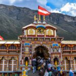 Vibrant view of Shree Badrinath Temple with pilgrims gathered around, set against a mountainous backdrop.